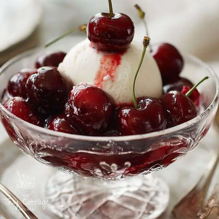 Cherries jubilee over ice cream in a parfait glass